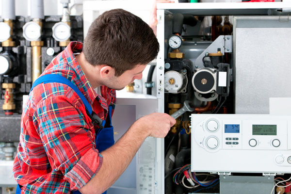 HVAC technician inspecting an indoor heating system in Chandler, AZ