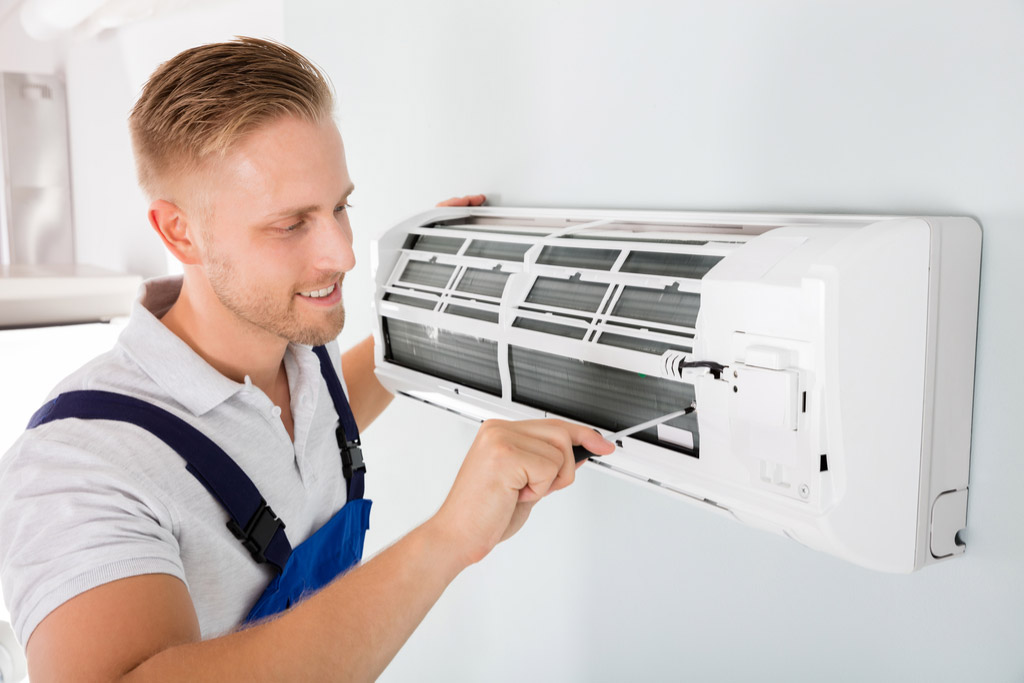 HVAC technician performing ductless air conditioning maintenance in Chandler