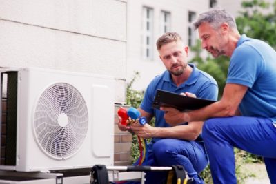 ac-installation-in-claremont-ca HVAC technicians reviewing an outdoor air conditioning unit in Chandler, AZ