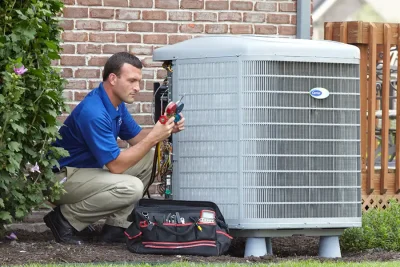 design-air-heating-and-air-conditioning-decatur-il-05 – Copy HVAC technician inspecting an outdoor air conditioning unit in Chandler, AZ