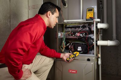 furnace repair Heating and air conditioning technician servicing an indoor furnace in Chandler, AZ